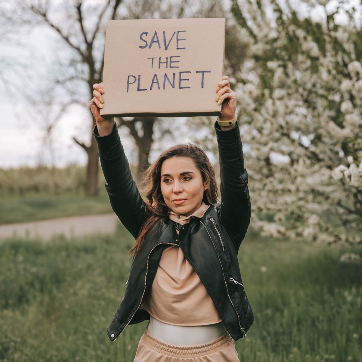 A woman holding up a "save the planet" sign. 