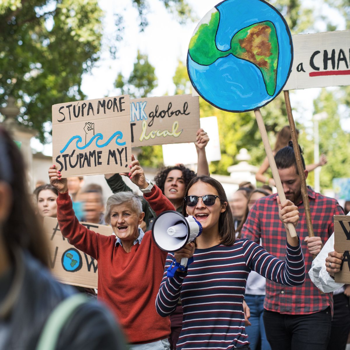 Effective advocates and young people at a protest holding signings urging to save the planet.