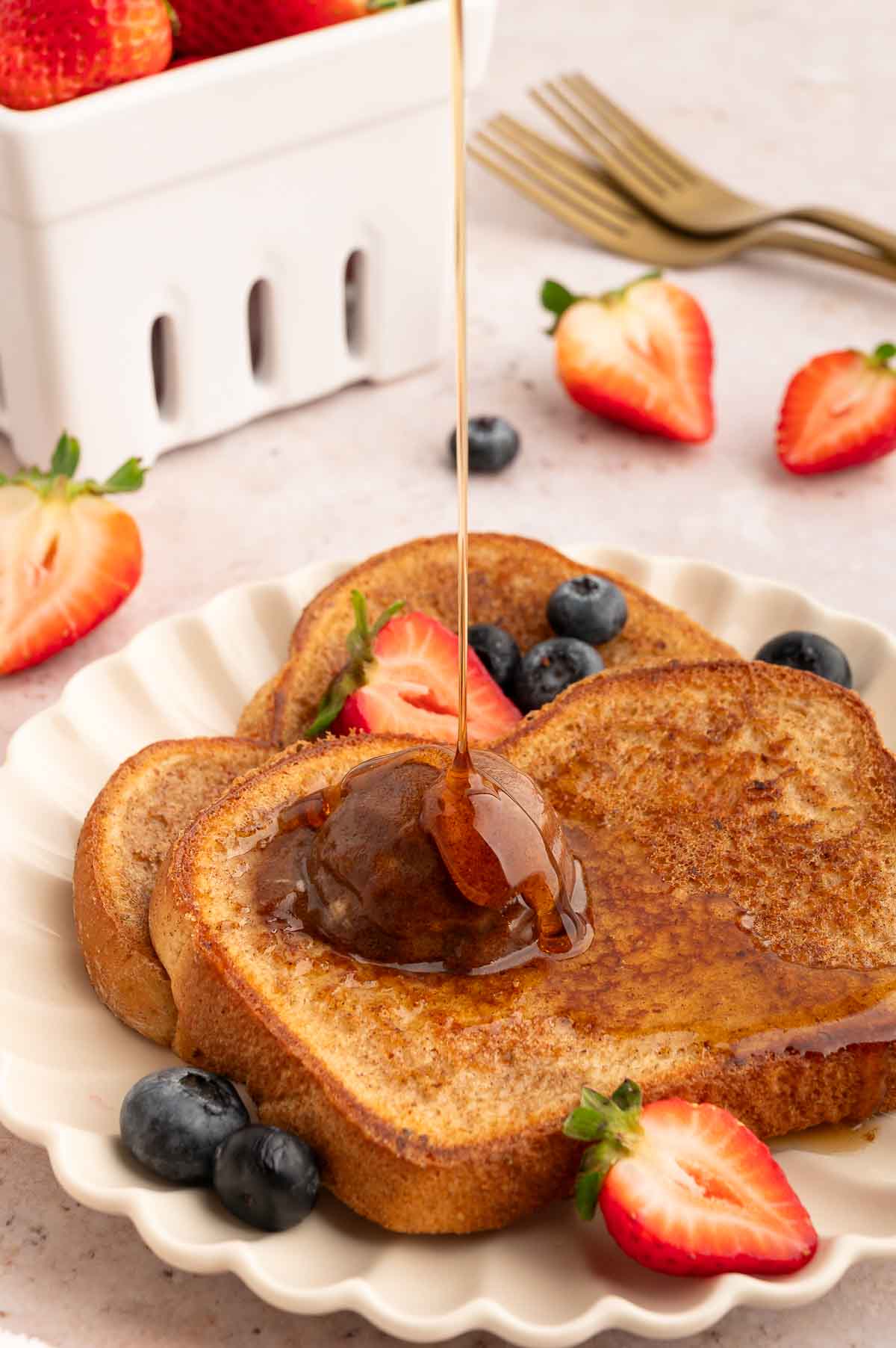 A plate of vegan French toast drizzled with maple syrup.