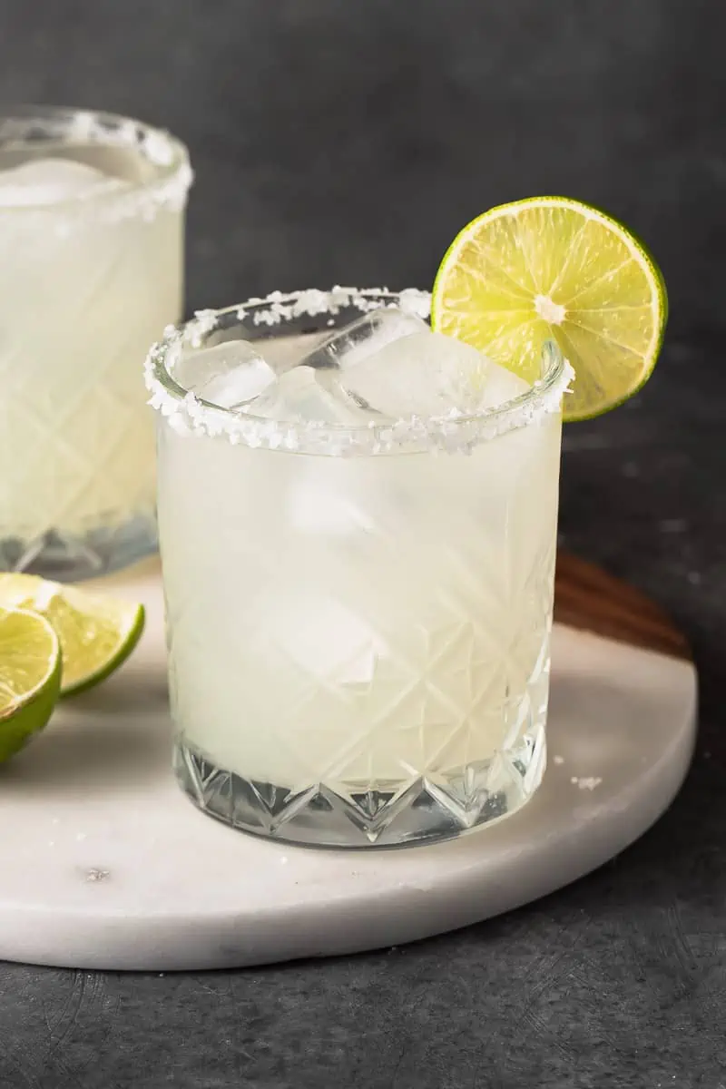 Classic margarita in a small glass with a lime slice on the rim.