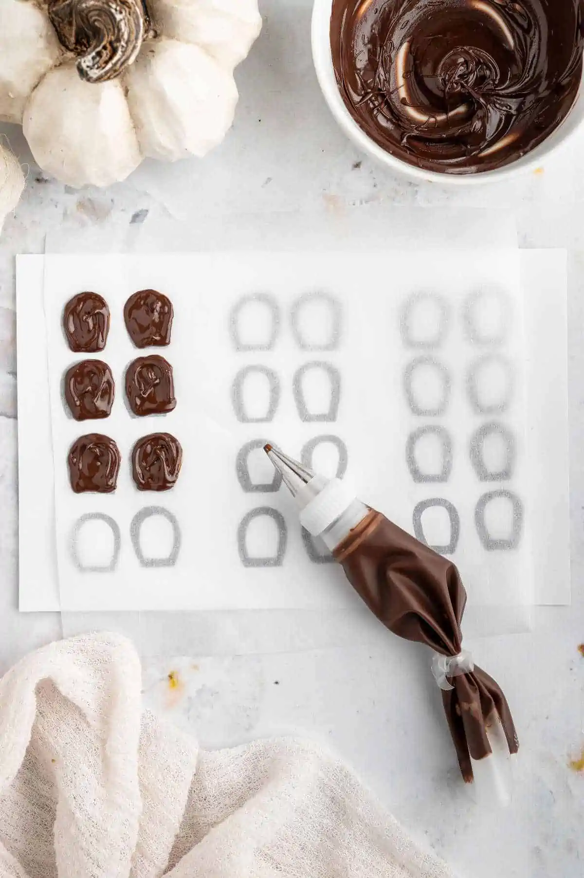 Tracing melted chocolate over the mice ear drawings onto wax paper.