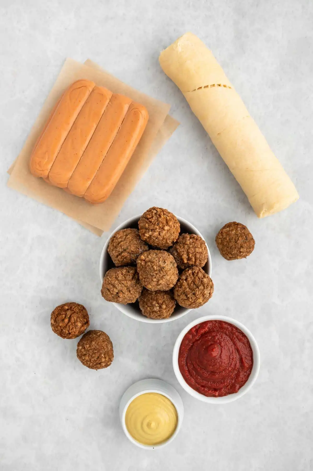 Flatlay of ingredients for vegan mummy dogs and balls on a light background.