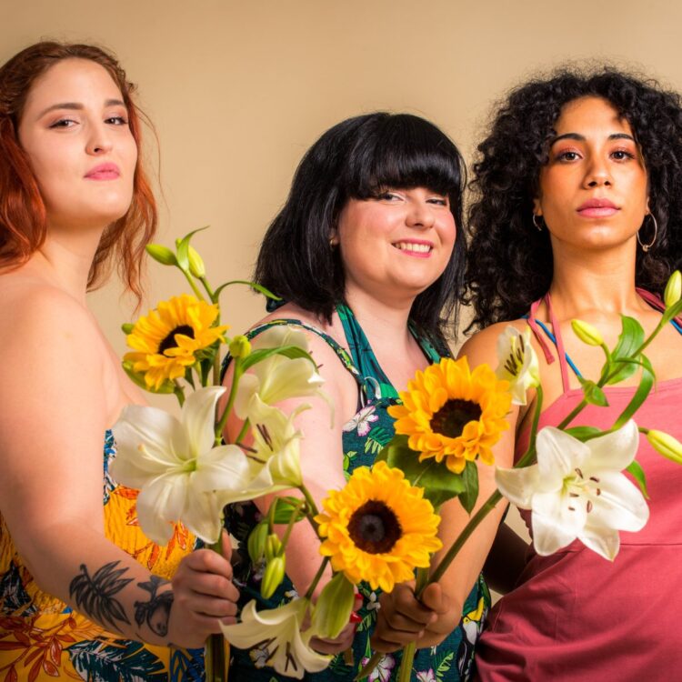 A photo of three women holding sunflowers with different body types and sizes representing weight diversity.