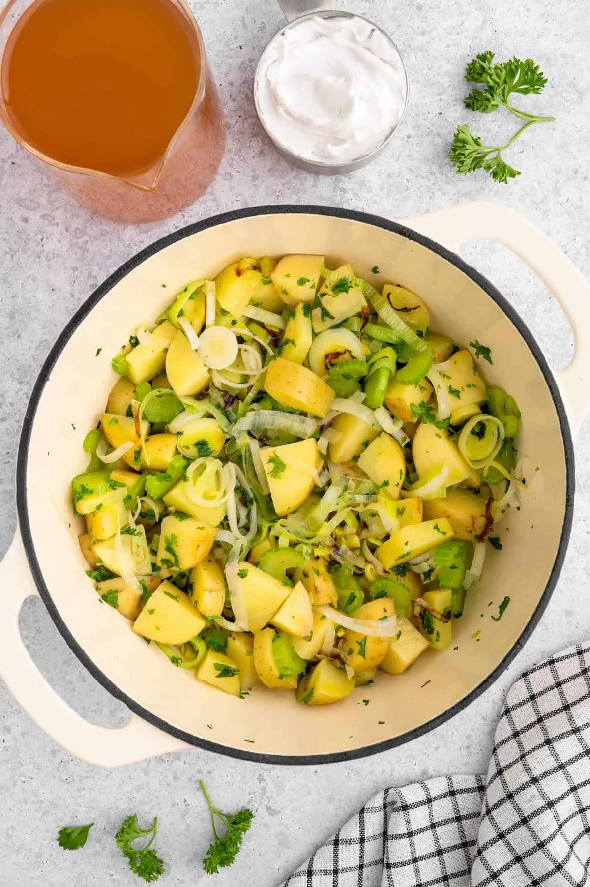 Chopped leeks, potato, celery, and parsley in a large dutch oven.