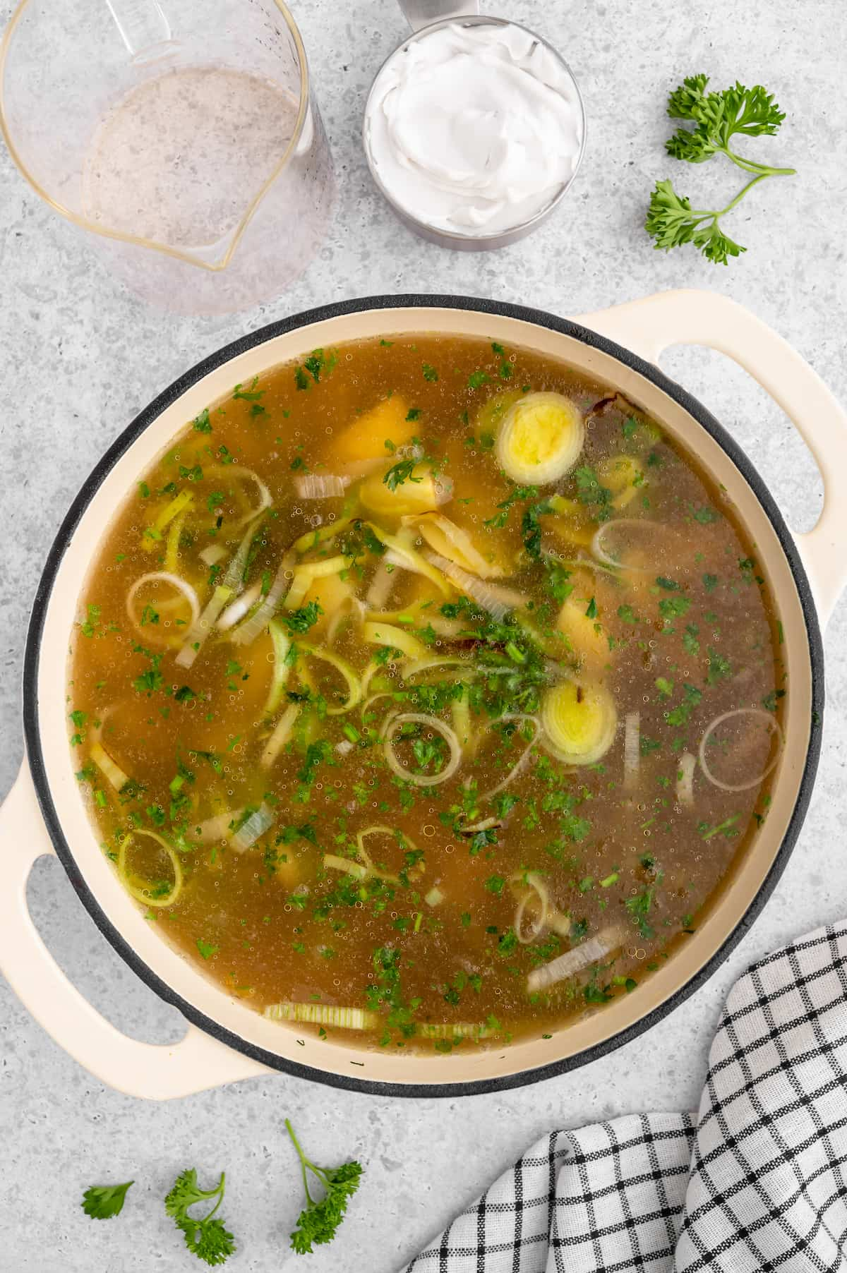 Broth added to the potato leek soup cooking in a dutch oven.