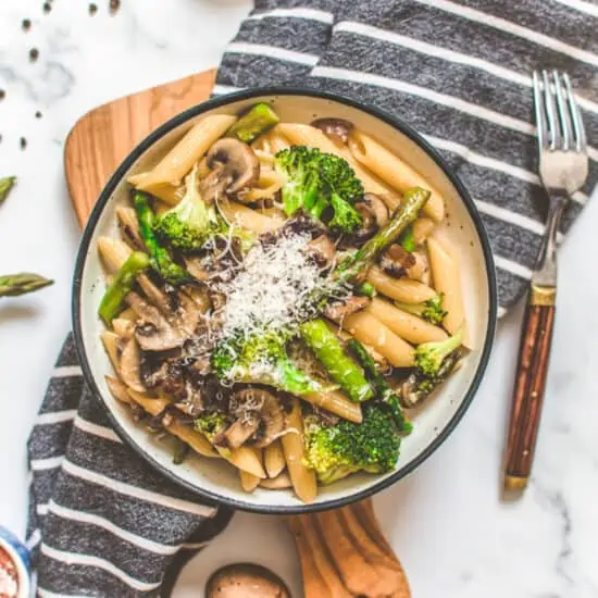 Pasta Dish Served with Vegetables on a Bowl topped with Grated Vegan Cheese