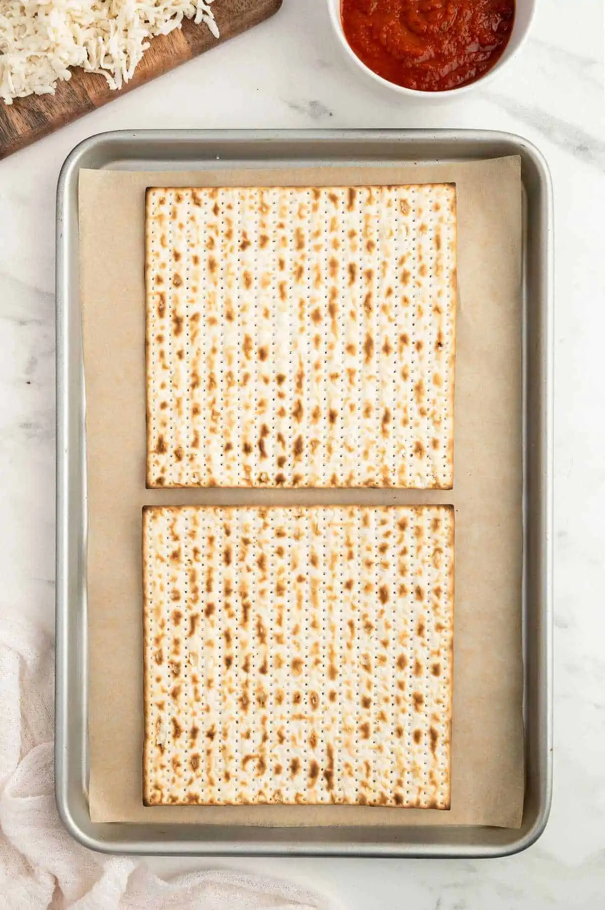 Two matzah crackers on a baking tray.