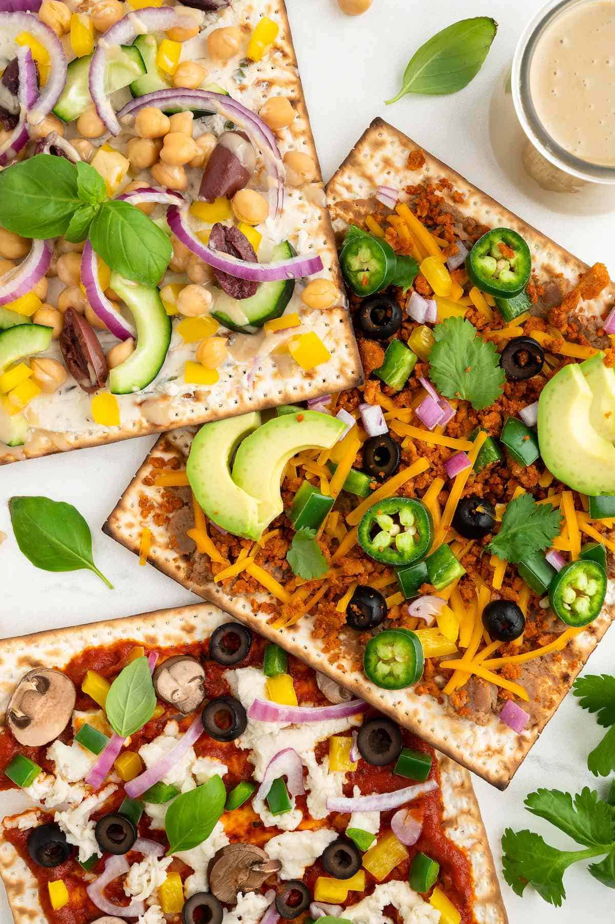 Three different varieties of matzah pizza including Greek, taco-style and veggie.