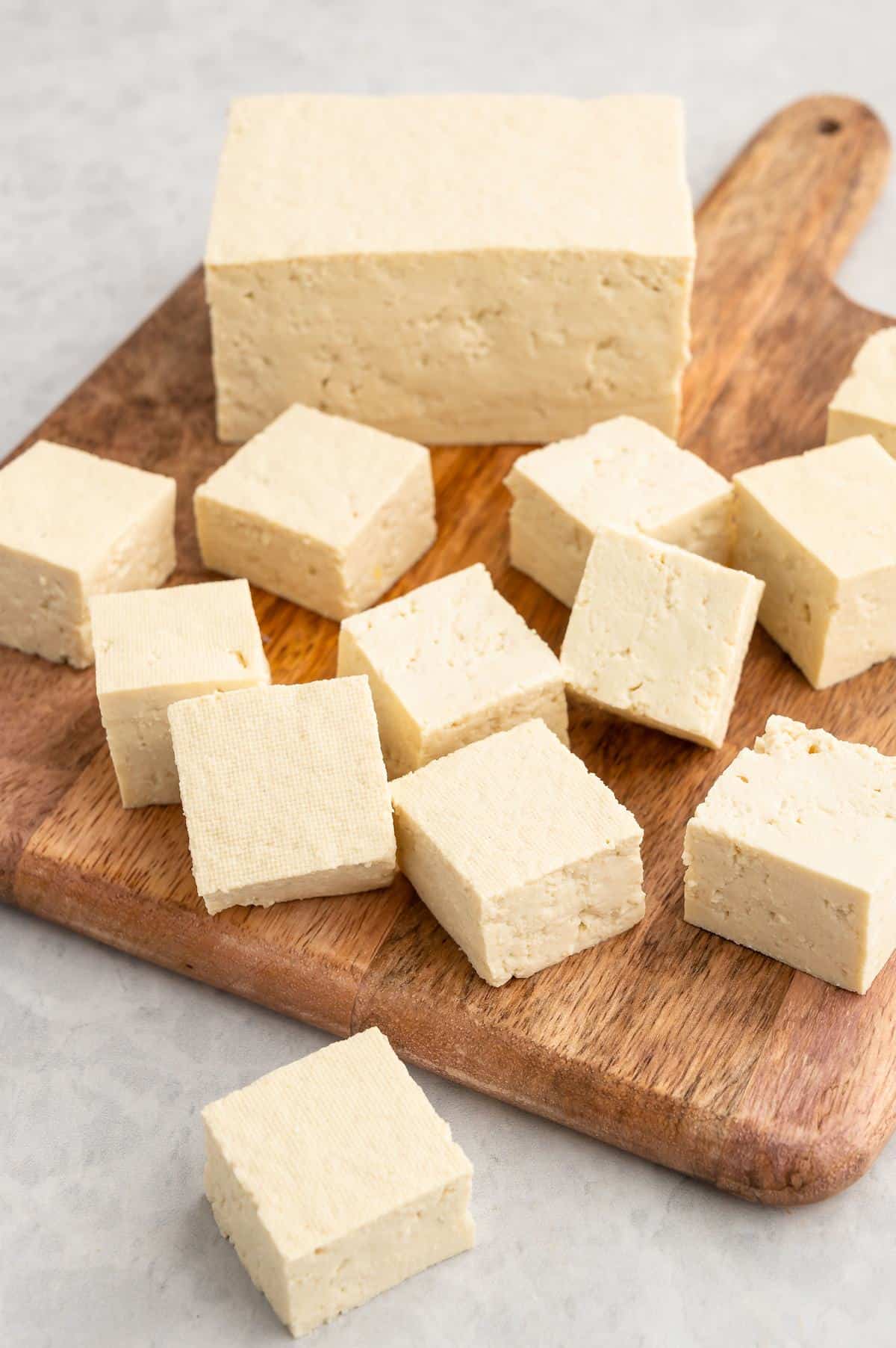 Cubed tofu on a cutting board.