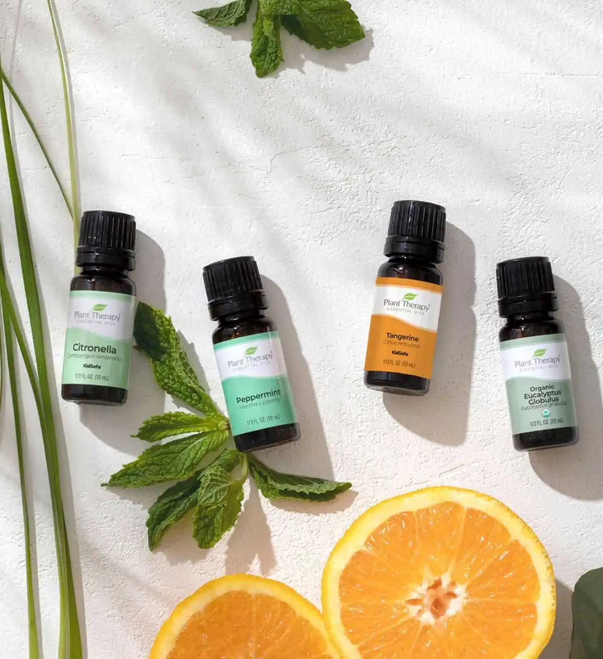 Four bottles of essential oils against a white background.