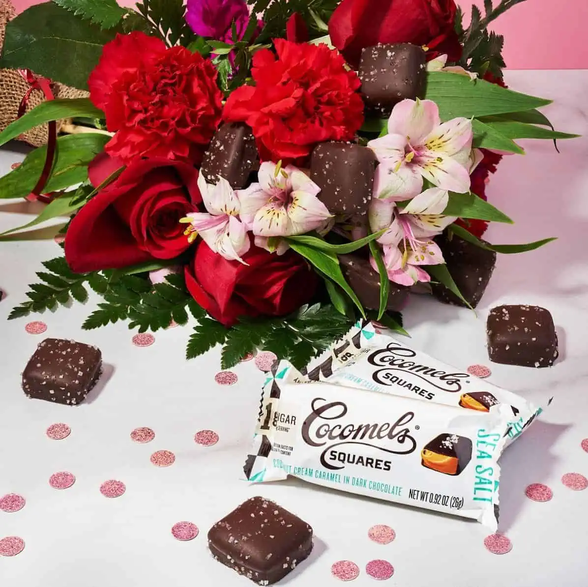 Cocomel squares next to a bouquet of flowers.