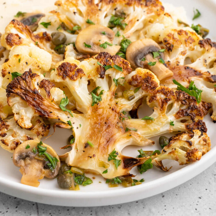 Roasted cauliflower steaks served over mashed potatoes and piccata sauce.