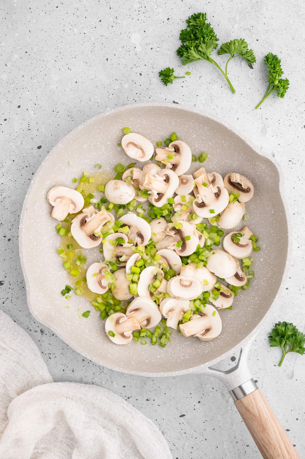 Mushrooms, scallions, and oil in a pan.