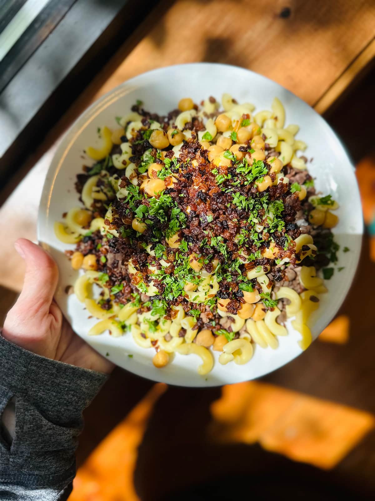 Koshari, a classic Egyptian vegan dish with rice, lentils, pasta, and tomato sauce.