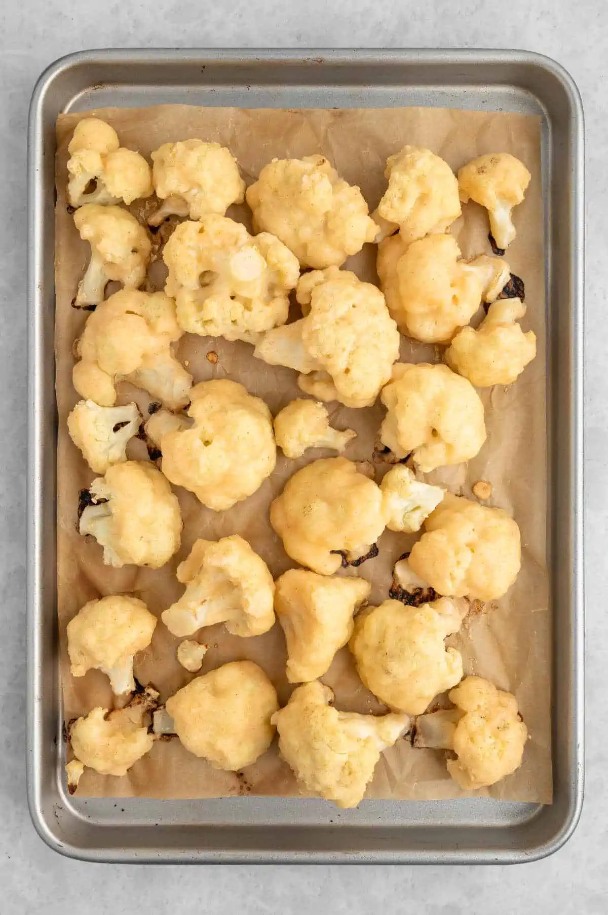 Vegan buffalo cauliflower wings on baking tray after being baked.