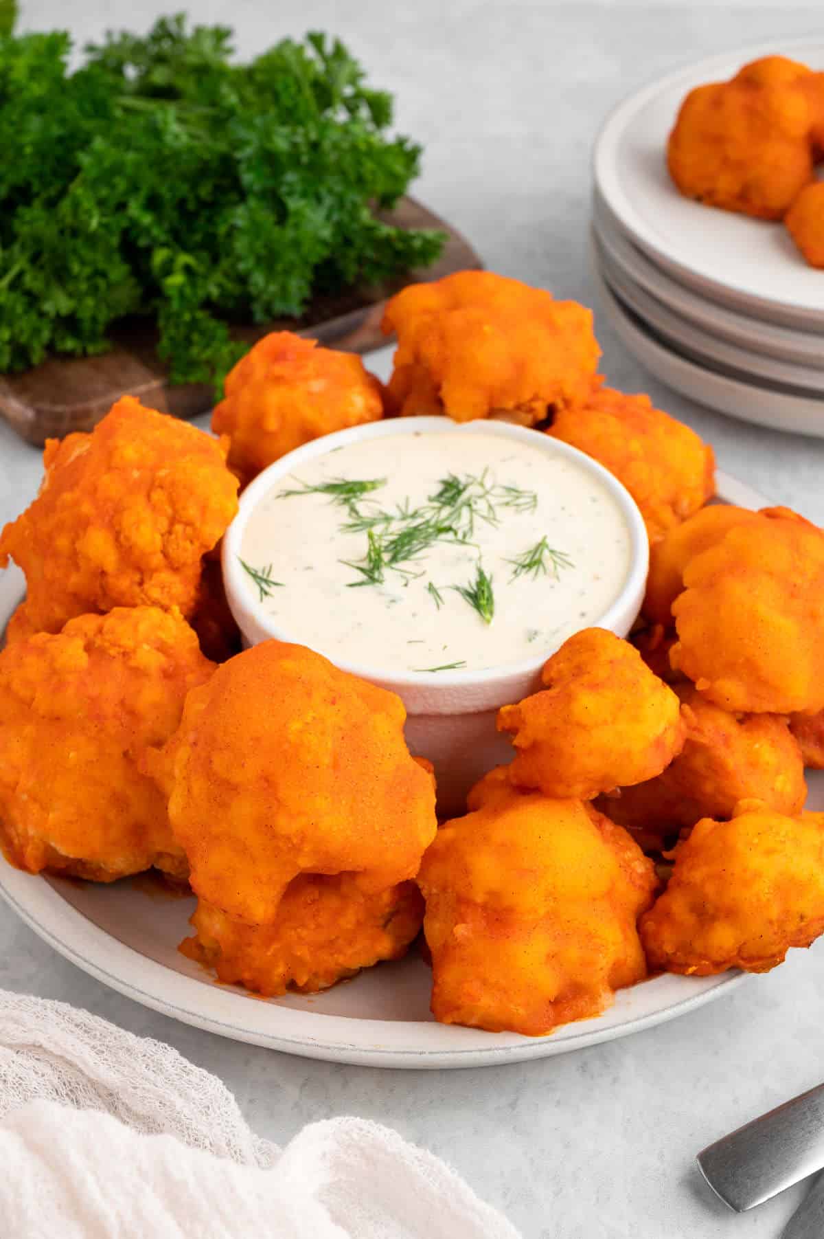 Vegan buffalo cauliflower wings on a plate with vegan ranch dip.