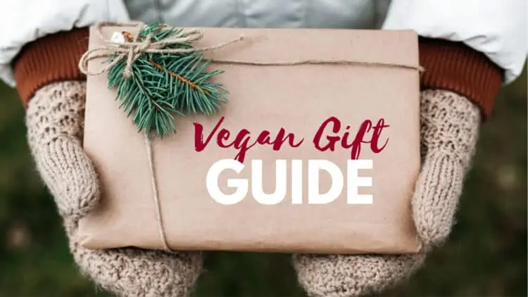 Woman wearing gloves holding a vegan gift wrapped in eco-friendly paper.