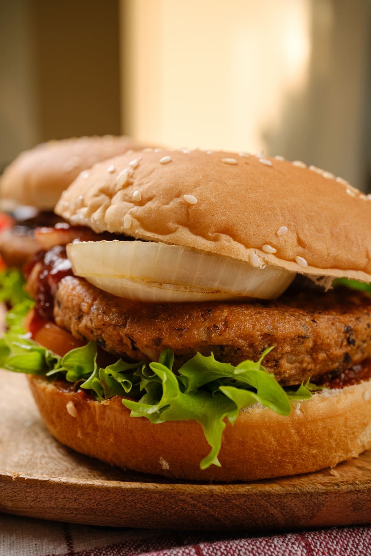 Chipotle black bean burger in a bun with lettuce, tomato, onion, and vegan BBQ sauce.