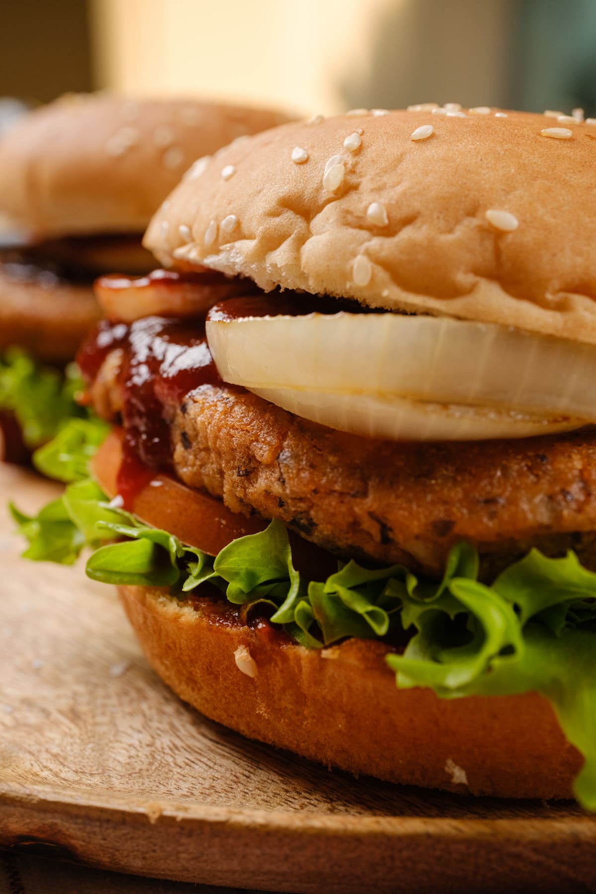 Chipotle black bean burgers served on a sesame seed bun with lettuce, tomato, onion, and BBQ sauce.