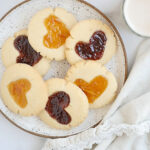 A plate of vegan thumbprint cookies with jam filling.