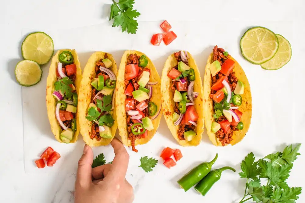 A hand reaching for a vegan taco.