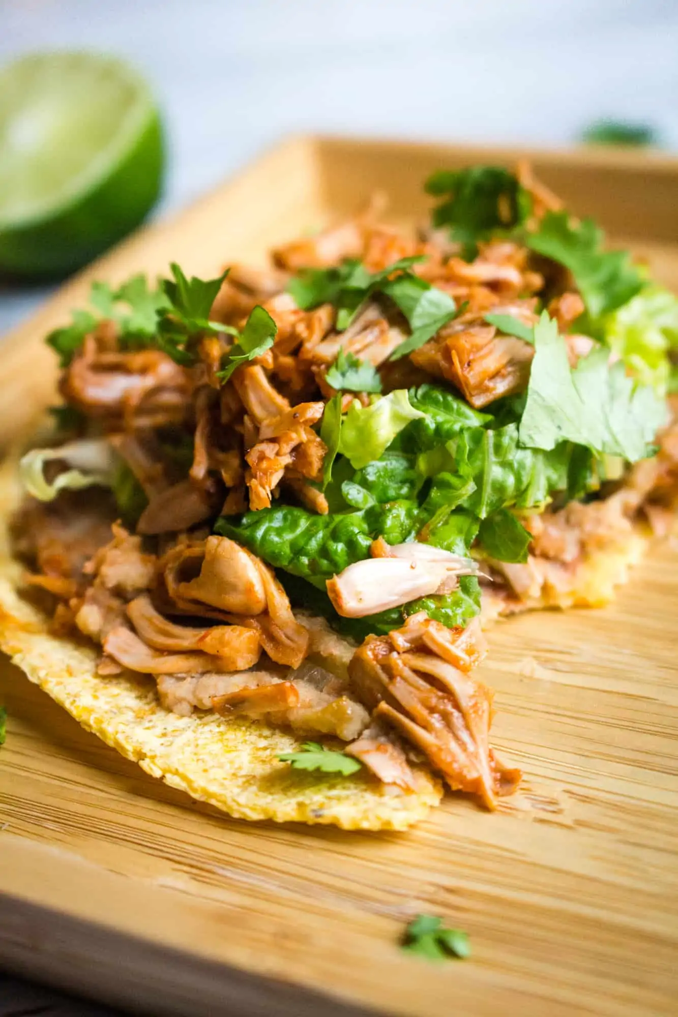 Jackfruit tostada on a wooden serving platter.