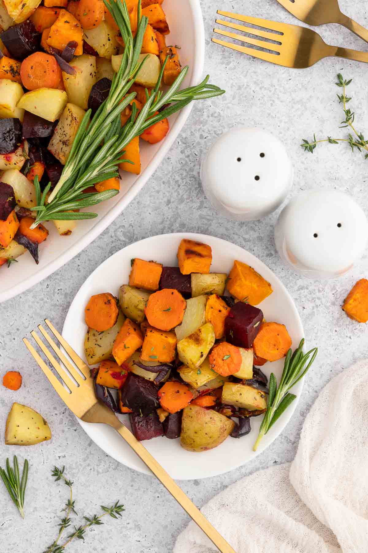 Roasted root vegetables in a serving bowl and smaller plate.