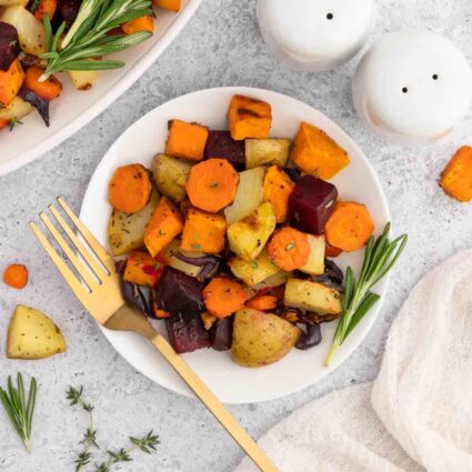 Roasted root vegetables on a white plate.