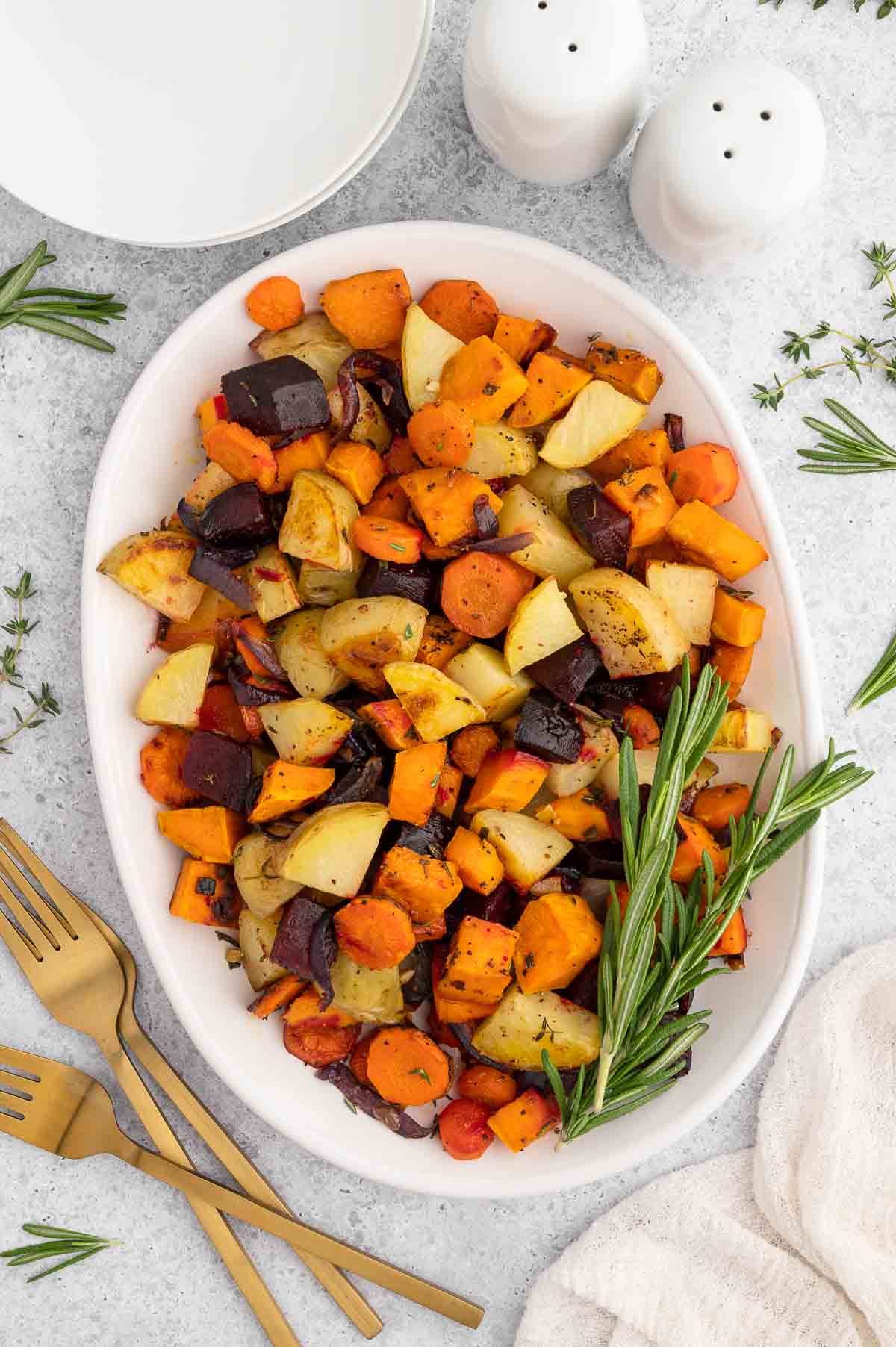 Roasted root vegetables in a white serving vessel.