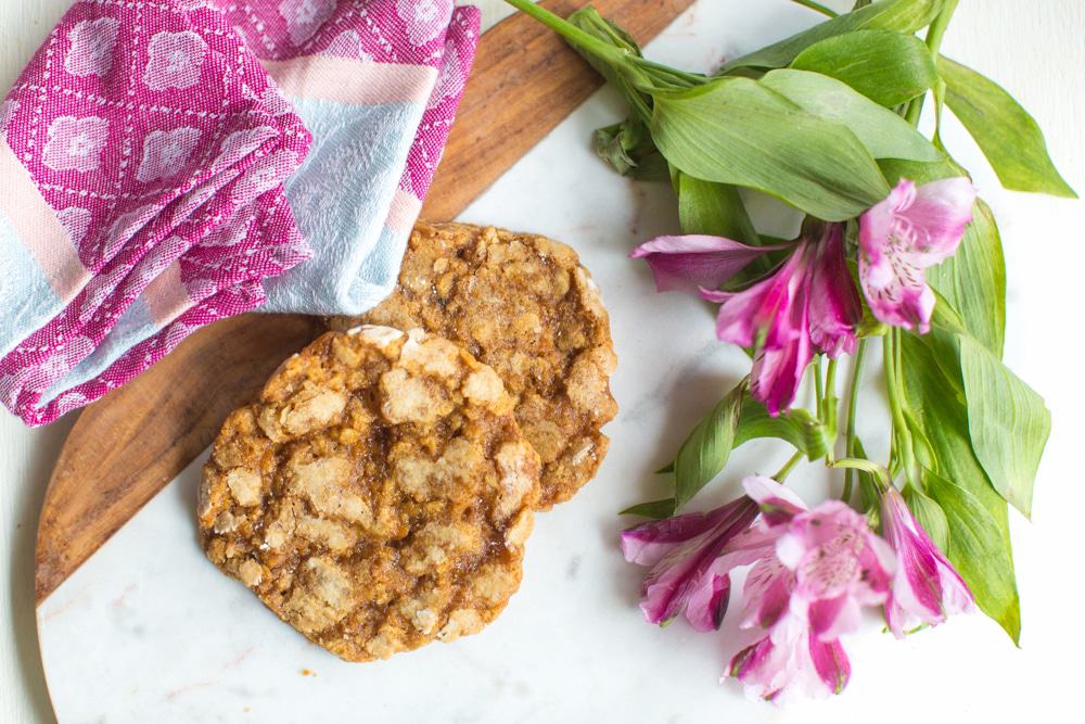 vegan oatmeal cookies on a cutting board with flowers