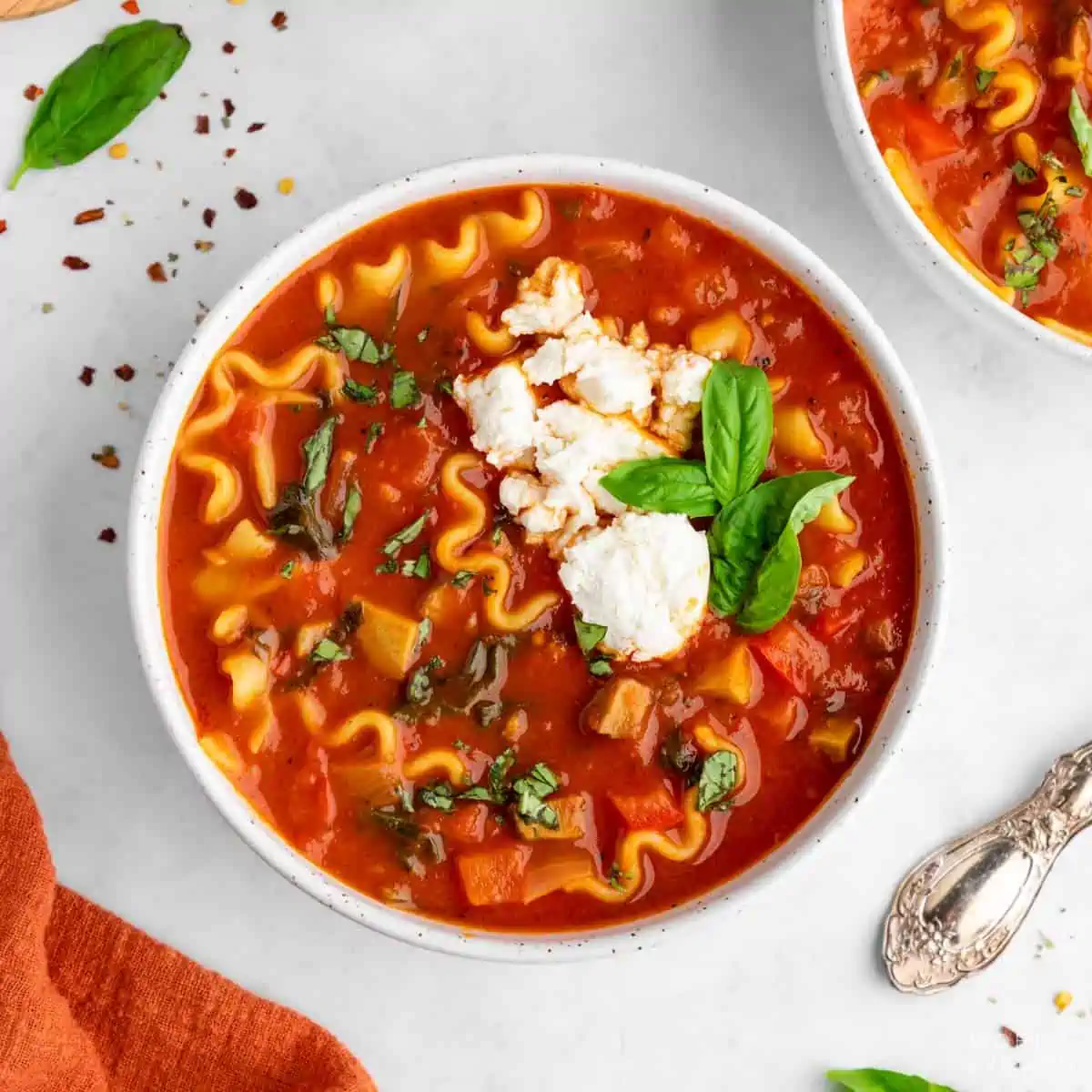 Bowl of vegan lasagna soup with tofu ricotta and basil and marinara sauce.