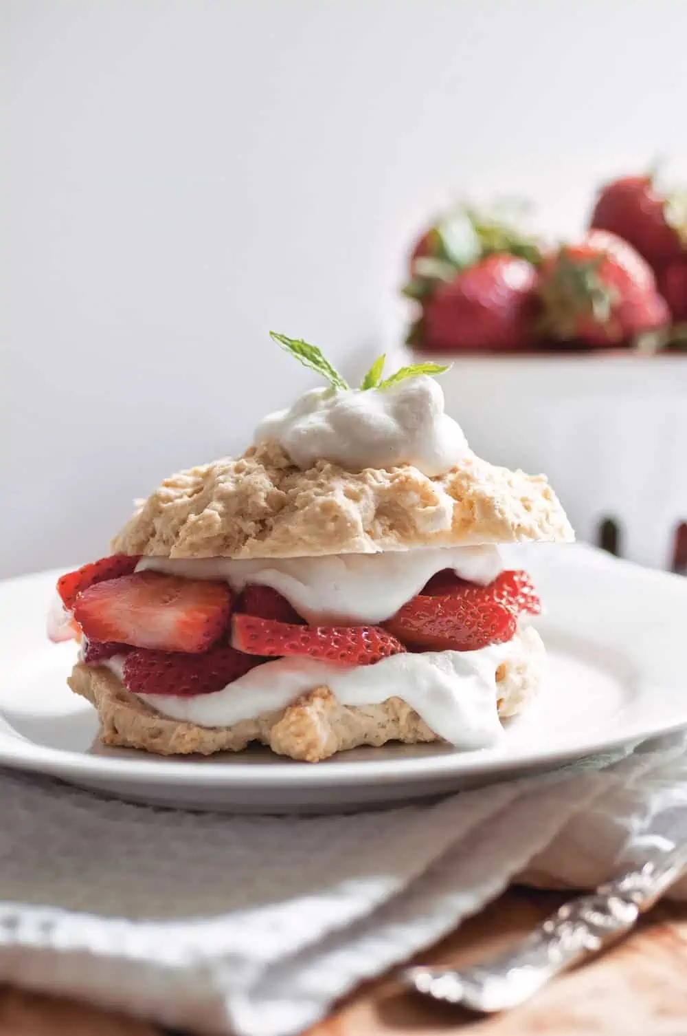 Easy Vegan Strawberry Shortcake stacked with biscuit whipped cream and fresh strawberries.