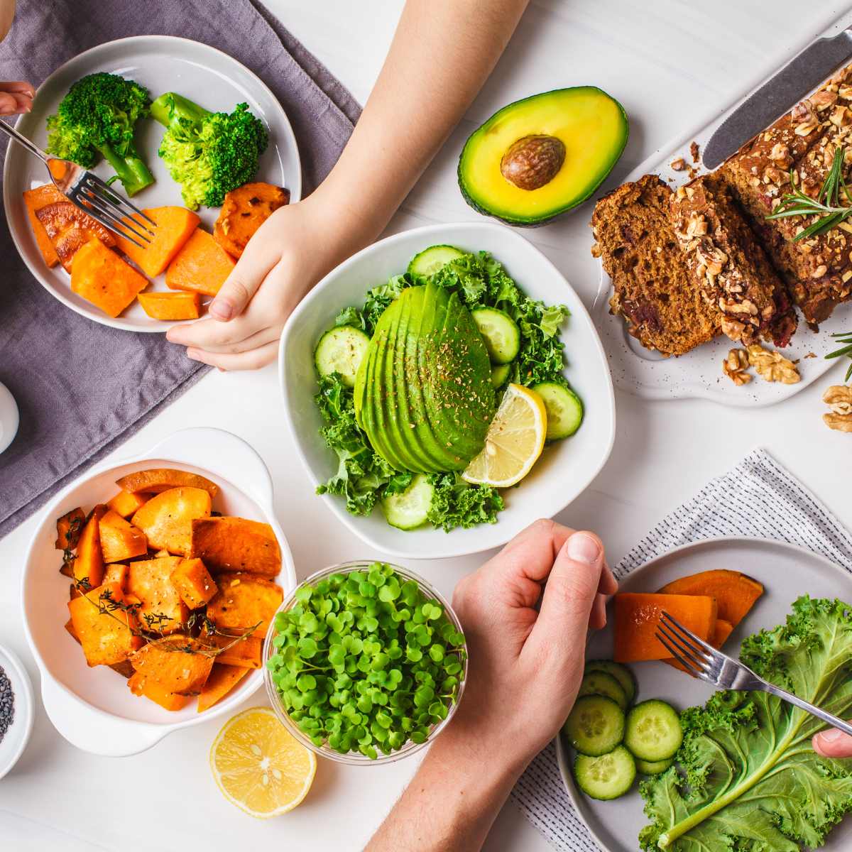 A plant-based dinner spread on a table with a family eating around it.