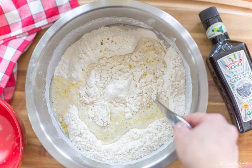 mixing flour with ingredients to make focaccia bread dough