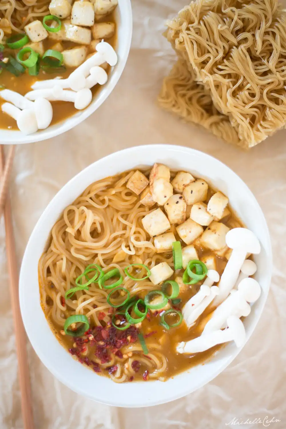 Bowl of vegan ramen noodle soup topped with tofu, mushrooms and green onion.