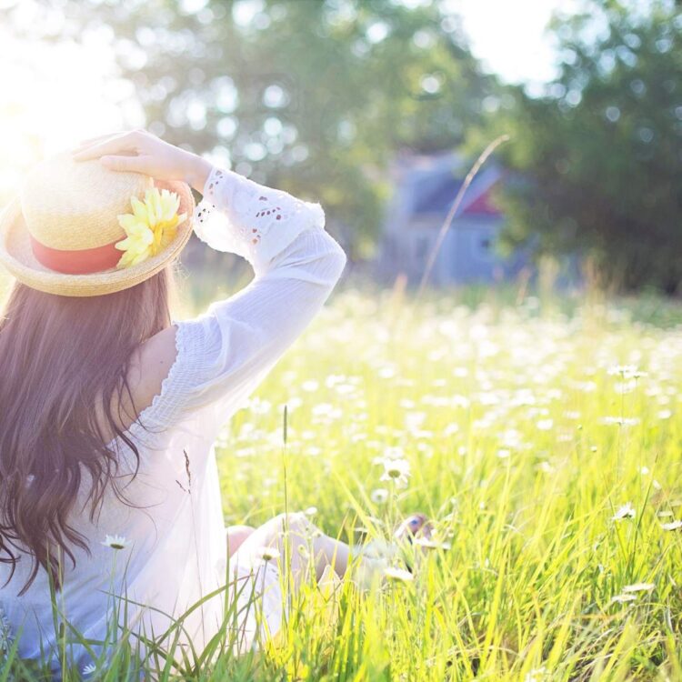 A woman in a field with sunshine, absorbing vegan vitamin d through the sun.