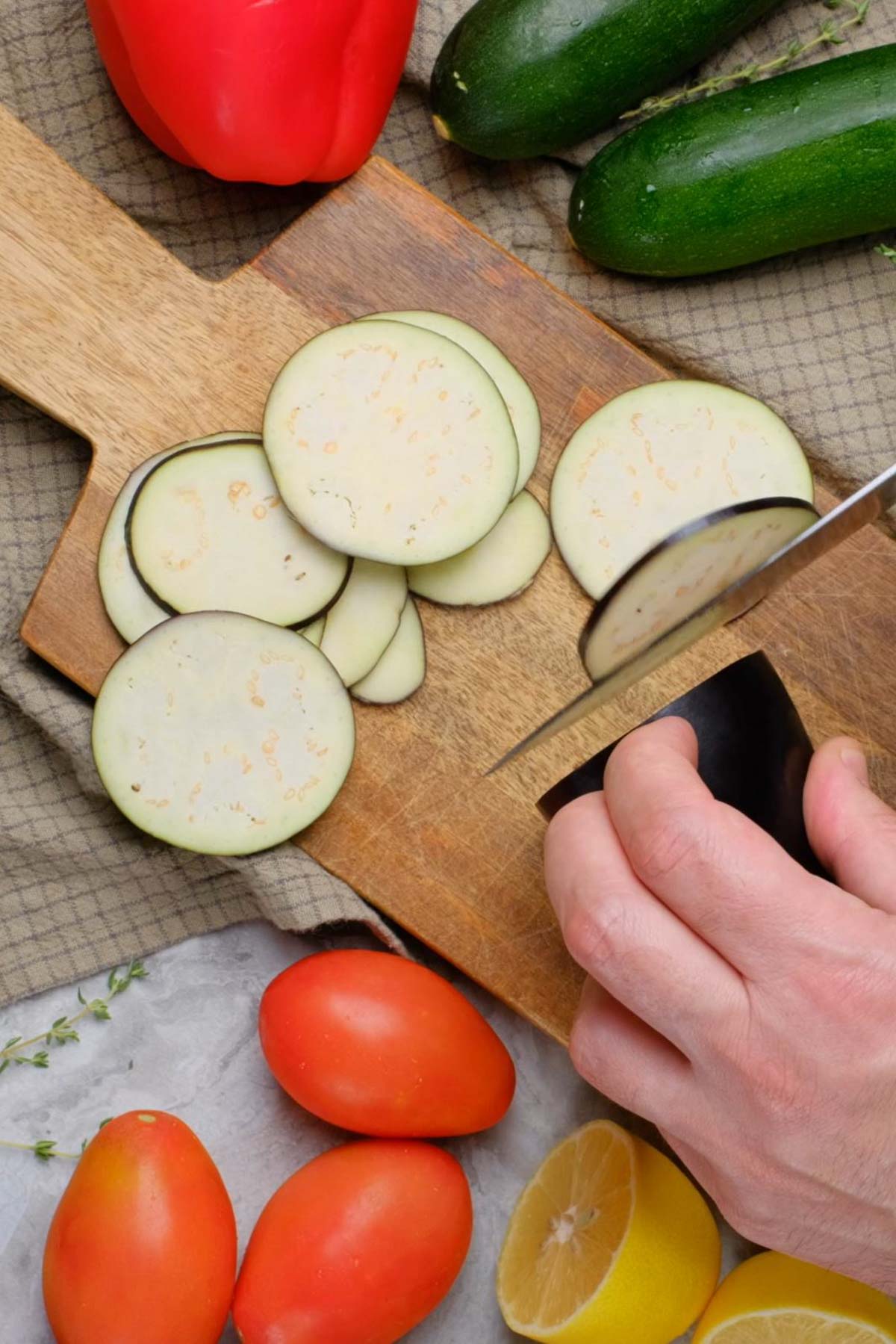 Vegetables being sliced on a wooden countertop.
