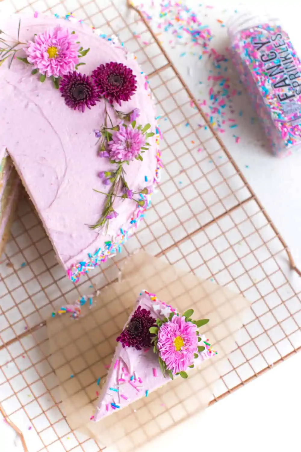Vegan cake with pink icing made with natural food coloring and sprinkles. 
