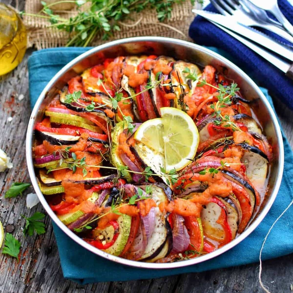 Ratatouille, garnished with lemon slices and herbs.