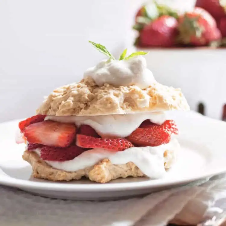 Vegan strawberry shortcake in a stack on a serving platter.