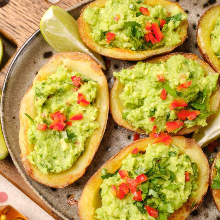A plate of loaded potato skins with guacamole.