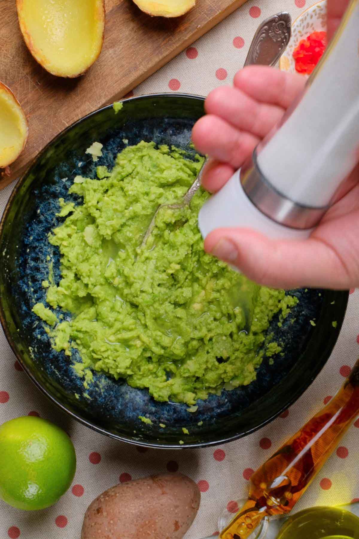 A bowl of guacamole seasoned with salt.