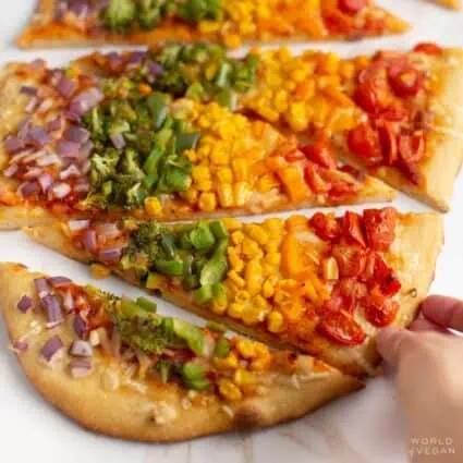 Rainbow pizza cut into slices.
