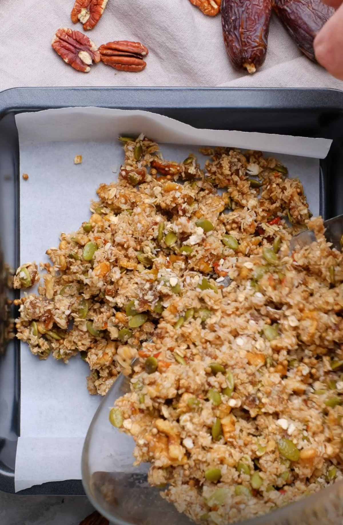 A granola bar mixture being transferred to a baking sheet.