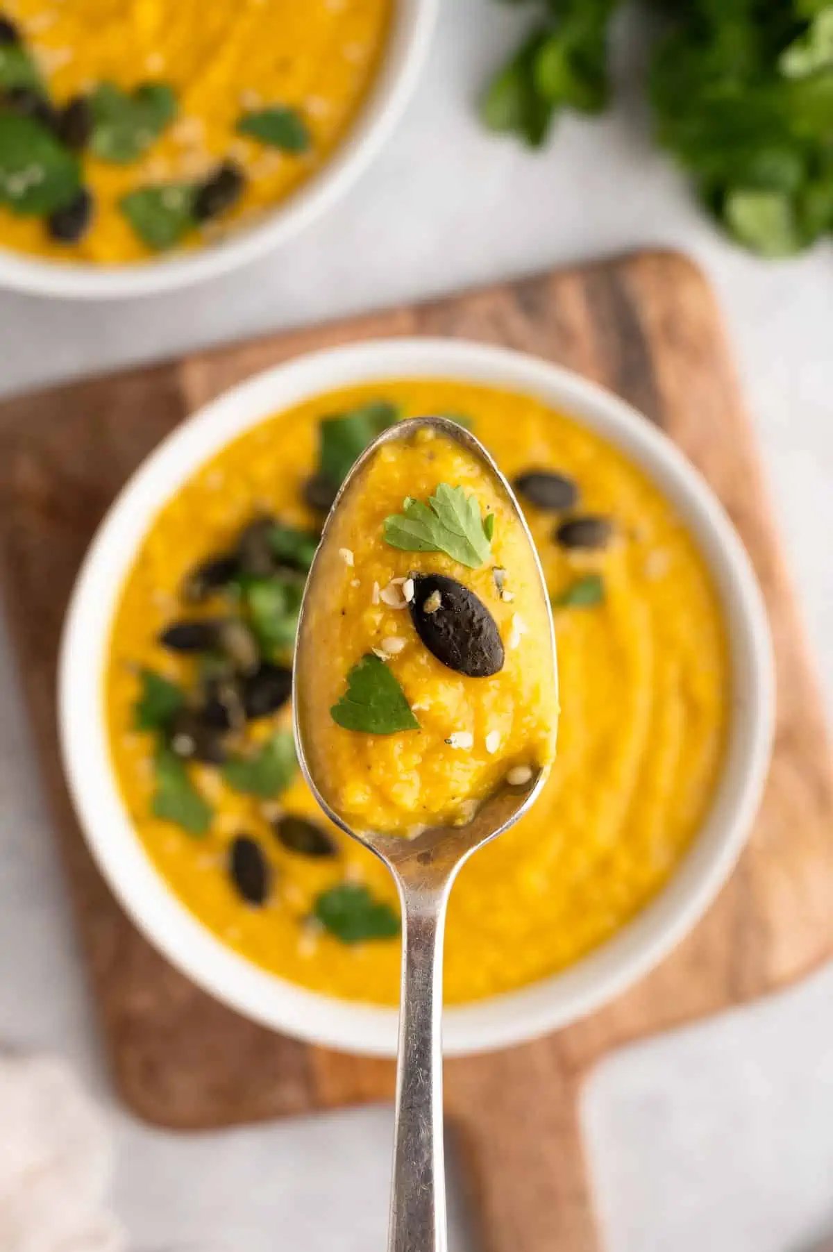 A spoonful of toor dal being held over a bowl. 