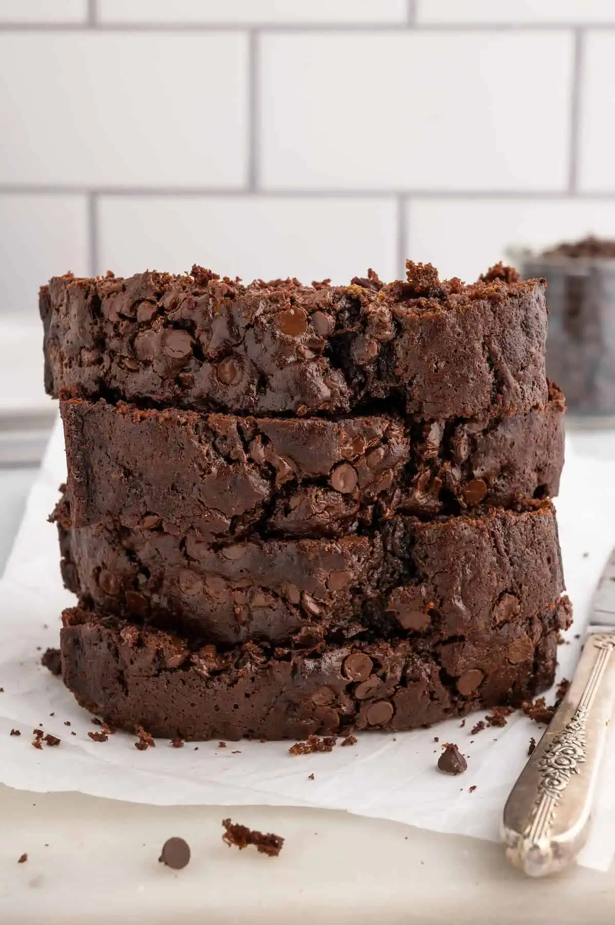 Slices of vegan chocolate zucchini bread, stacked on a countertop.