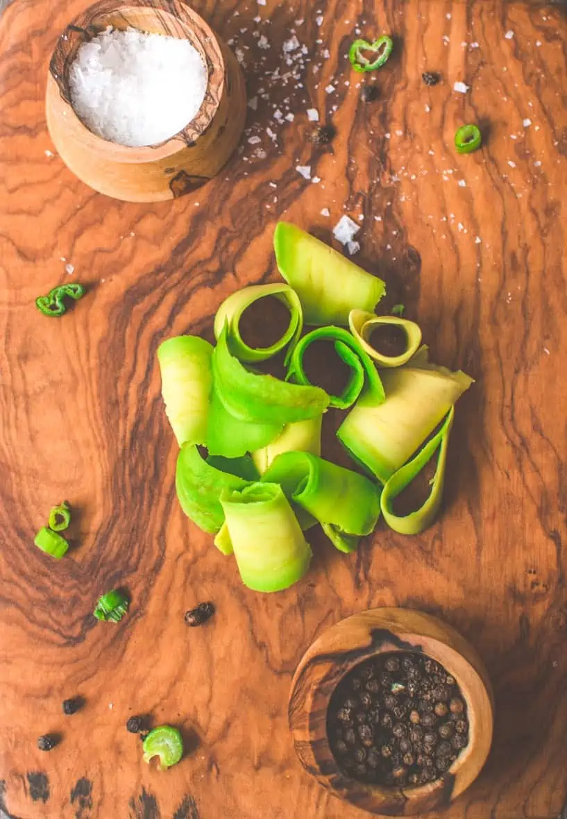 Avocado sliced with a peeler and in a pile.