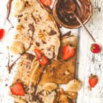 Crepes folded in triangles, topped with vegan nutella and sliced strawberries and bananas.