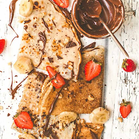 Crepes folded in triangles, topped with vegan nutella and sliced strawberries and bananas.