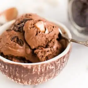 Vegan Rocky Road Ice Cream scooped into a bowl with dairy free chocolate and vegan marshmallows.